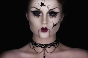 Model in creative image. Spooky talking broken doll. photo