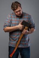 Bearded man with axe posing in studio photo