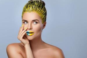 Beautiful woman with yellow hair and colorful nails and lips photo