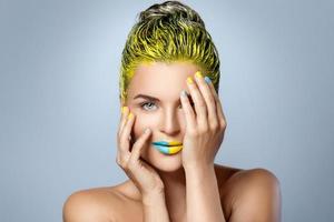 hermosa mujer con cabello amarillo y uñas y labios coloridos foto