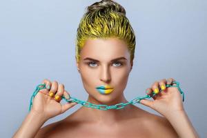 Beautiful woman with yellow hair and colorful nails and lips photo