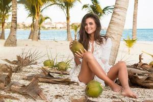 Woman and lot of coconuts on the ground photo