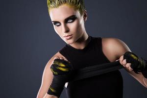 Woman mma fighter with yellow hair in studio photo