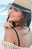 Beautiful woman wearing a hat on the beach photo