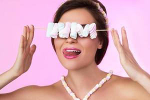 Happy beautiful woman with marshmallows on the skewer photo