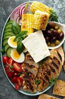 Grilled chicken platter with vegetables, eggs, feta cheese photo