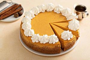 Pumpkin cheesecake with fall spices topped with whipped cream photo