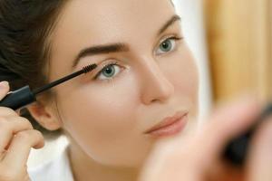 Beautiful woman is applying tinted eyebrow gel photo