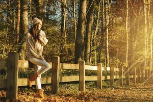 Young and happy woman in the park at sunny autumn day photo