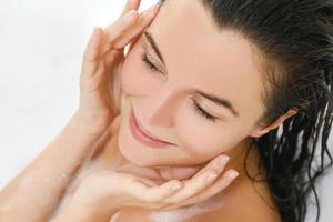 Young woman is taking bath with a pleasure photo