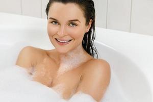 Young woman is taking bath with a pleasure photo