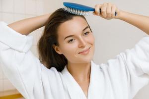 mujer peinándose con un cepillo para el cabello foto