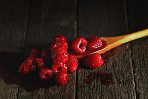 Homemade sweet raspberry jam on wooden table photo