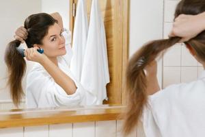 Woman with a beautiful strong hair looking into the mirror photo