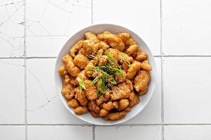 Orange chicken with green onions and sesame seeds photo