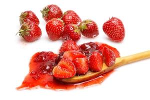 Strawberries and jam in the spoon on white background photo