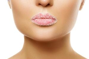Close up of female lips with sugar photo