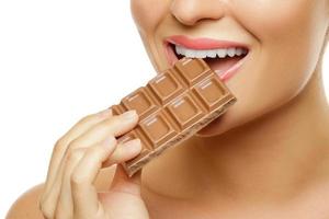 Female mouth and chocolate bar on white photo