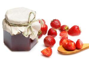 Jar of jam and strawberries on white background photo