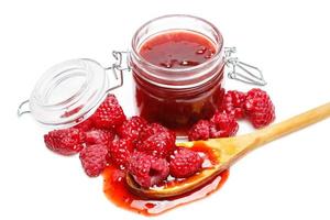 Jar of jam and raspberries on white background photo