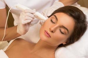 Woman during face skin diagnostic in the professional beauty clinic photo