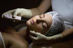 mujer en un salón de spa de belleza profesional durante el procedimiento de limpieza facial ultrasónica foto