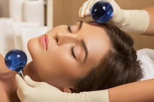 Woman in beauty salon during treatment with a cold glass balls photo