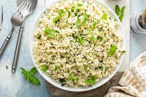 Cauliflower rice with herbs and lemon juice in a white bowl photo