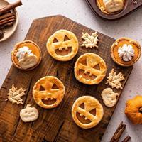 Halloween pumpkin pies with carved pumpkin face on top photo