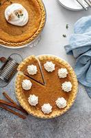 Traditional pumpkin pie with whipped cream and cinnamon photo