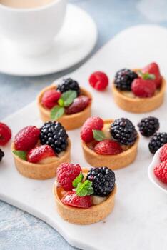 tartaletas de bayas frescas con relleno de crema pastelera y menta foto