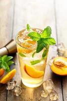 Summer peach mojito cocktail with fresh mint, lime and peach slices photo