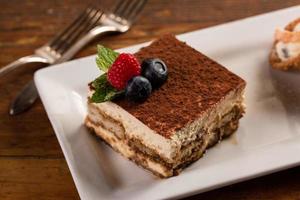 postres italianos tradicionales, tiramisú y cannoli en el plato foto