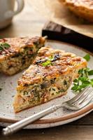 Bacon, mushroom and spinach quiche with cheese and herbs photo