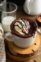pastel de chocolate en una taza con helado y chispas foto