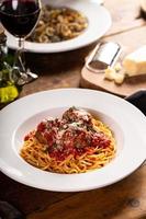 Spaghetti with meatballs and marinara sauce on a wooden table photo