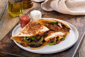 Beef brisket and green pepper quesadillas with sour cream and salsa photo