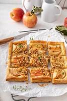 Apple tart with puff pastry tpped with walnuts and brown sugar photo