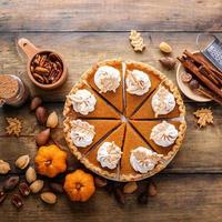 Traditional Thanksgiving pumpkin pie cut into slices photo