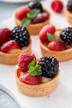 tartaletas de bayas frescas con relleno de crema pastelera y menta foto