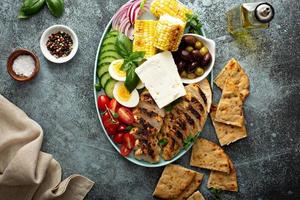Grilled chicken platter with vegetables, eggs, feta cheese photo