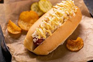 Hot dog with sauerkraut and mustard on parchment photo