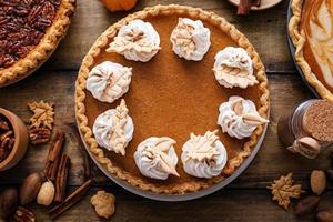 Traditional Thanksgiving pumpkin pie topped with whipped cream photo