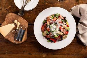 Italian antipasto salad with salami, artichoke hearts and olives photo