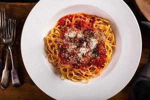 espaguetis con albóndigas y salsa de tomate en un plato foto