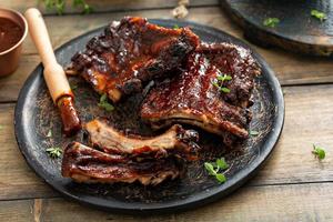 Grilled barbeque ribs with BBQ sauce and sides photo