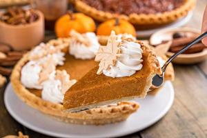 Slice of pumpkin pie with whipped cream on top photo