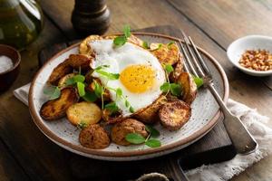 Rustic roasted potatoes with fried egg for breakfast