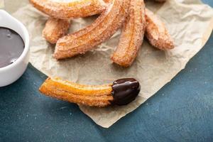 churros caseros con azúcar de canela sobre pergamino foto