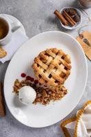 Individual apple pie served with ice cream and granola photo